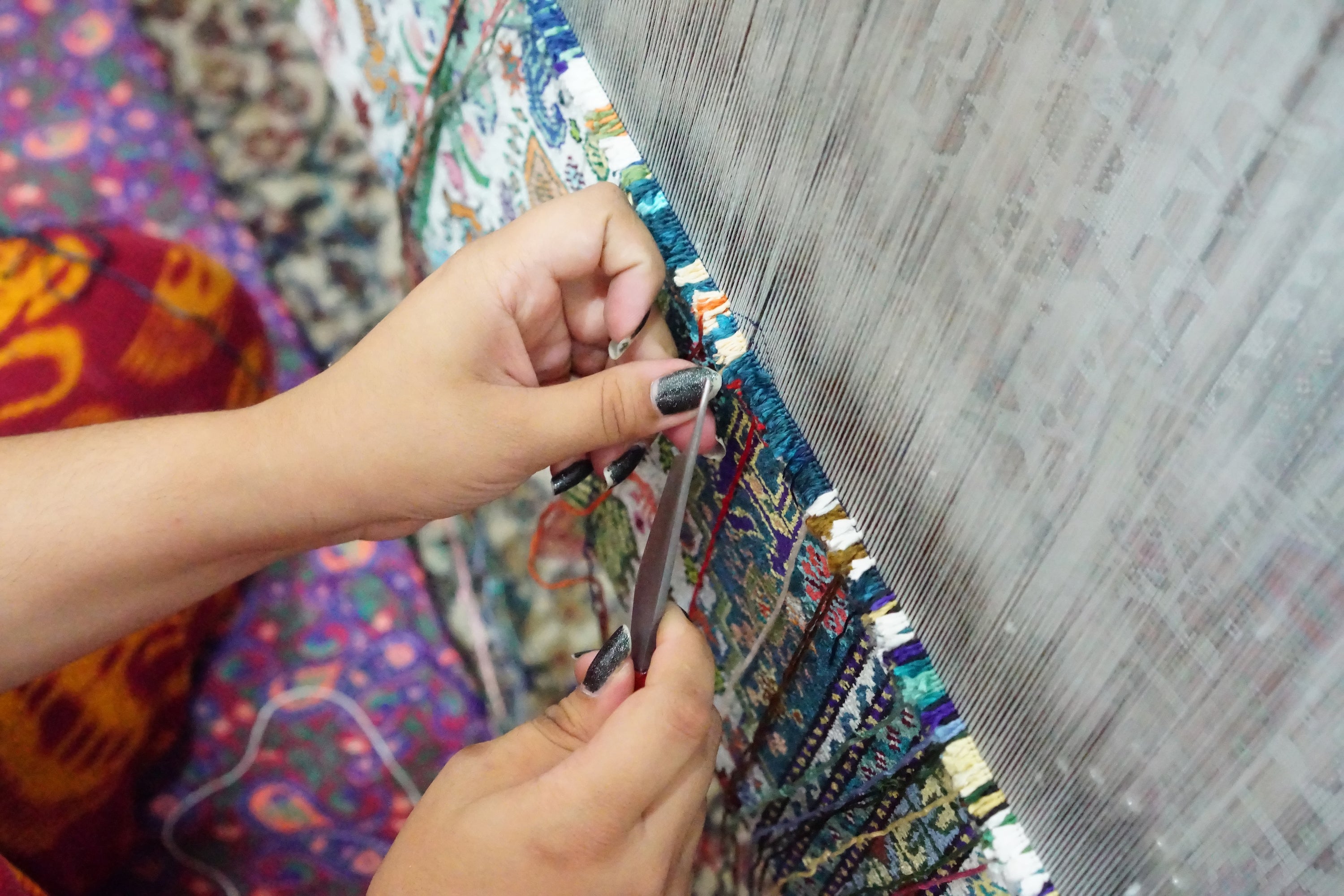 Master artisan weaving hand-knotted rug at Opulent Rugs workshop in India